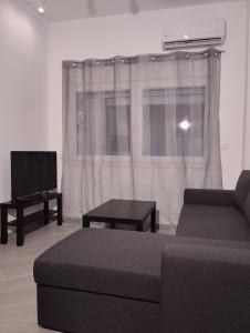 - un salon avec un canapé et une télévision dans l'établissement Juliet IsimeriaHomz, à Thessalonique