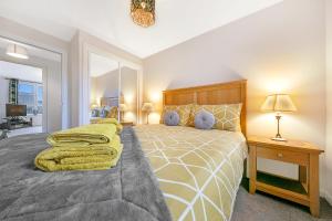 Un dormitorio con una cama grande y una mesa con una lámpara. en Kings Lodge - Grampian Lettings Ltd en Aberdeen