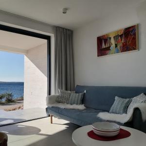 a living room with a blue couch and a view of the ocean at Bella Mare in Mandre