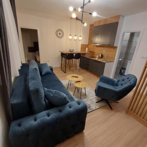 a living room with a blue couch and a kitchen at Tijana 2 in Pale