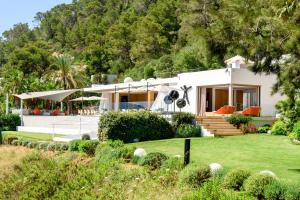 a house with a green lawn in front of it at Sa Caleta Hill in Sant Josep