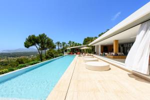 a villa with a swimming pool and a house at Sa Caleta Hill in Sant Josep