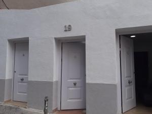 trzy drzwi na boku białego budynku w obiekcie Apartamento C w Madrycie