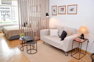sala de estar con sofá blanco y cama en Maipú 812 by depptö en Buenos Aires