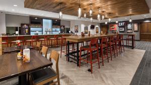 um bar num restaurante com mesas e cadeiras de madeira em Holiday Inn - Clarksville Northeast , an IHG Hotel em Clarksville