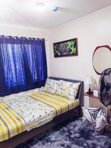 1 dormitorio con 1 cama y una ventana con cortinas azules en 8 spatial condo near downtown, coffee shop, SNR, Sm, hospital, Schools 2b fully furnished, en Davao City