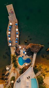 una vista aérea de un muelle con sombrillas y piscinas en Hotel Mercedes en Ilhabela