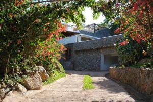 un camino de piedra que conduce a una casa con flores en Propiedad de alto standing con vista al mar, piscina, tenis, hasta 12 personas en Las Terrenas