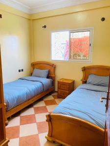 a bedroom with two beds and a window at Sea Surf House Imsouane in Imsouane