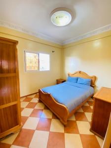 a bedroom with a bed and a checkered floor at Sea Surf House Imsouane in Imsouane