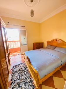 a bedroom with a bed and a large window at Sea Surf House Imsouane in Imsouane