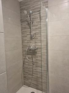 een douche met een glazen deur in een badkamer bij L'ALPIN in Bourg-Saint-Maurice