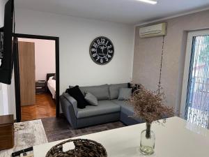 uma sala de estar com um sofá e um relógio na parede em Holiday Home Lupita 2 em Vinjerac