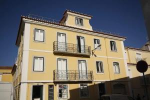 里斯本的住宿－Timeless Charming - Belém，黄色的建筑,上面有两个阳台