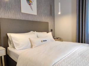 a bed with white sheets and pillows in a room at Apartamenty Turystyczne WillkasSen in Giżycko +35 photos