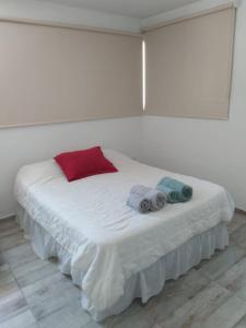 a white bed with two towels on top of it at Aires de la costa Renovado in Neuquén