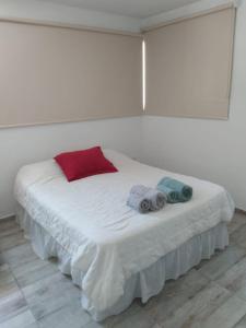 Una cama blanca con dos toallas encima. en Aires de la costa Renovado en Neuquén