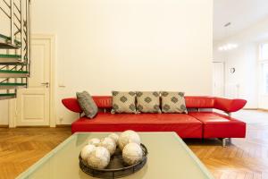 塔林的住宿－Old Town - Vene Apartment，客厅配有红色的沙发和桌子