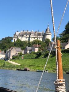 vista su un castello da una barca in acqua di Le clos fleuri - Chambres d'hôtes a Onzain