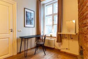 una mesa en una habitación con una silla y una ventana en Old Town - Vene Apartment, en Tallin