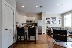 a kitchen with white cabinets and black bar stools at Cashville - Stylish Condo Minutes from Broadway in Nashville