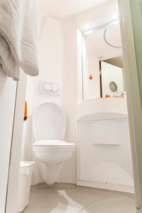 a white bathroom with a toilet and a mirror at easyHotel Edinburgh in Edinburgh