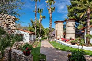 un jardin avec des palmiers et une maison dans l'établissement Tubac Golf Resort & Spa, à Tubac