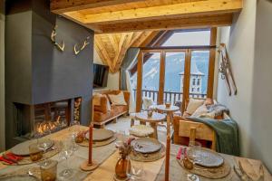 a living room with a table and a fireplace at WOW views next to the ski lift! in Baqueira-Beret