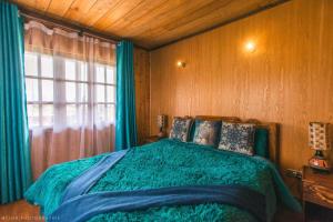 a bedroom with a green bed and a window at The Wonky House in Timau