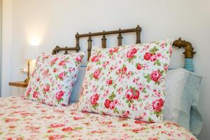 Una cama con dos almohadas rosas y blancas. en Casa Flor, en Zahora