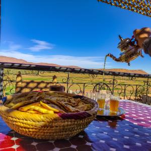 a basket of food and a glass of beer on a table at Riad Al Anwar in Tinerhir