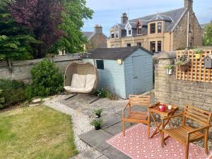 a backyard with a table and a chair and a fence at Best location in town, it is all on the doorstep. in Ayr