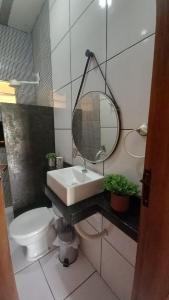 a bathroom with a sink and a toilet and a mirror at Casa na Praia de Saquaira - Península de Maraú. in Marau