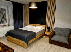 sypialnia z łóżkiem i krzesłem w obiekcie Willa "Aparthause" E-Apartamenty w Mielcu
