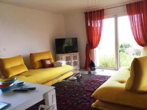 a living room with a yellow couch and a tv at Villa Roccu in Borgo