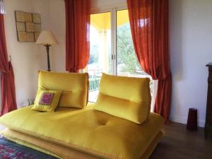 a yellow bed with two pillows in front of a window at Villa Roccu in Borgo