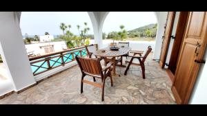 comedor con mesa y sillas en el balcón en Villa Almyra, en Aegina Town
