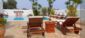 un grupo de sillas junto a una piscina en Villa Almyra, en Aegina Town
