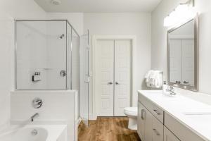 a white bathroom with a toilet and a sink at Kasa Greenville Dallas in Dallas