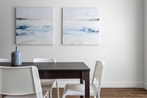 a dining room with a wooden table and white chairs at Kasa Greenville Dallas in Dallas