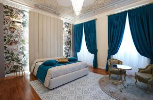 a bedroom with blue curtains and a bed and a table at Rosetta Burger Queen in Cagliari
