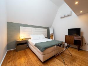 1 dormitorio con 1 cama y TV en Apartamentos Premium Familiares - Loft Guesthouse BeMyGuest Viseu en Viseu
