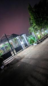 a white building with a gate at night at Naboya House Serviced Apartment in Benin City
