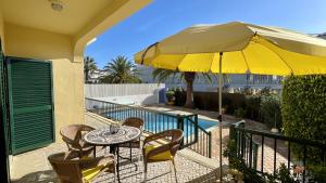 a patio with a table and a yellow umbrella at Margarida by Check-in Portugal in Albufeira