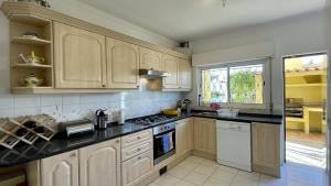 a kitchen with wooden cabinets and a stove top oven at Margarida by Check-in Portugal in Albufeira