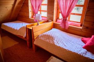 1 dormitorio con 2 camas en una cabaña de madera en Kućica na brijegu, en Selnica