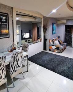ein Wohnzimmer mit einem Tisch, Stühlen und einem Sofa in der Unterkunft Cosmo mansion apartment in Jakarta