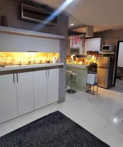 eine Küche mit weißen Schränken und einer Arbeitsplatte in der Unterkunft Cosmo mansion apartment in Jakarta