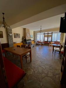 uma sala de estar com mesas e cadeiras e uma lareira em Ξενώνας Ράπτης 