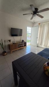 sala de estar con TV de pantalla plana y sofá en El Arrecife: Apartamento con alberca a 10 minutos de la playa, en Acapulco